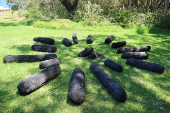 Akira Kamada’s Requiem – a circle of smooth, burnt tree trunks lying on the grass.