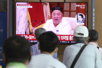People watch a screen showing a file image of North Korean leader Kim Jong-un during a news program in Seoul. 