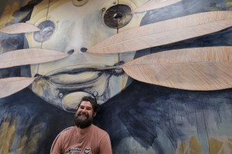 Artist Damien Kamholtz with his completed work displayed at the Queensland AI Hub headquarters in Brisbane’s Fortitude Valley.