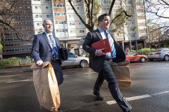 Investigators leave a public housing block in Fitzroy.  