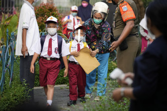 Students wearing face masks as an  elementary school in Jakarta, Indonesia re-opens in late August.