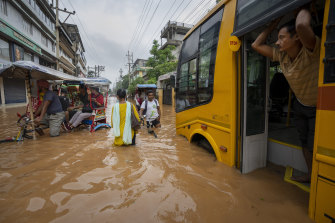 Trains were drowned and buses stranded as rivers flooded roads in Assam. 