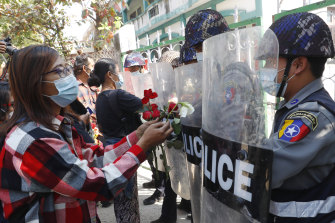Supporters give roses to police while four arrested activists make a court appearance in Mandalay, Myanmar, on Friday.