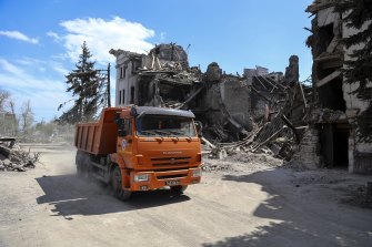A truck drives past the Mariupol theatre damaged during fighting in Mariupol in territory under the government of the Donetsk People’s Republic.