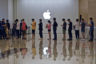 Orang-orang mengantre di Apple Store pada awalnya untuk membeli handset iPhone 13 terbaru, tetapi permintaan telah melemah.  