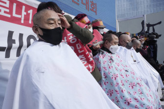 Small business owners have their heads shaved during a rally against the government’s social distancing rules in Seoul on Tuesday.