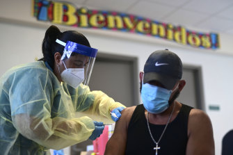 A healthcare worker injects a man with a dose of the Moderna COVID-19 vaccine in Vieques, Puerto Rico.