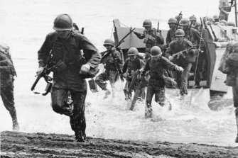 US Marines charge ashore on Guadalcanal Island from a landing barge during the early phase of the US offensive in Solomon Islands in August 1942, during World War II. 