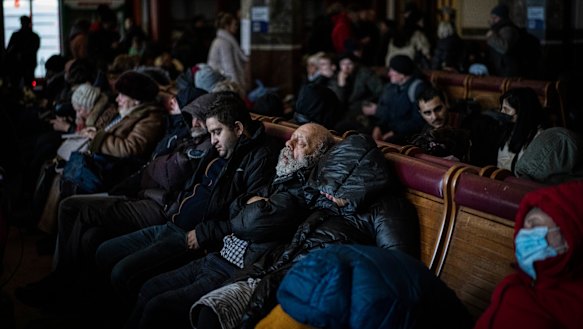 People trying to flee Ukraine sleep inside a crowded Lviv railway station on Monday.