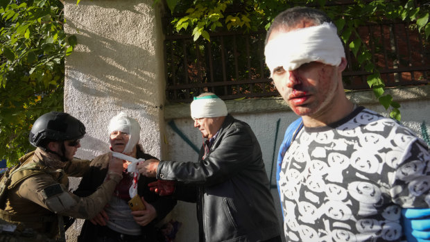 People receive medical treatment at the scene of Russian shelling, in Kyiv.