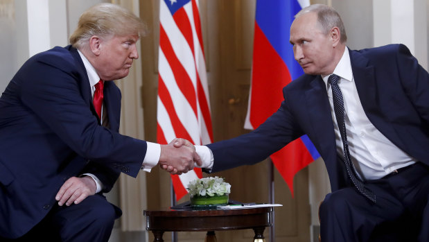 US President Donald Trump, left, and Russian President Vladimir Putin, right, shake hands at the beginning of a meeting at the Presidential Palace in Helsinki, Finland, on June 16. 