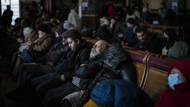 People trying to flee Ukraine sleep inside a crowded Lviv railway station on Monday.