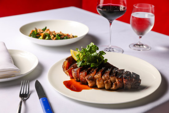 Kidman dry-aged sirloin on the bone, with coal-roasted greens, fried onion and black garlic.