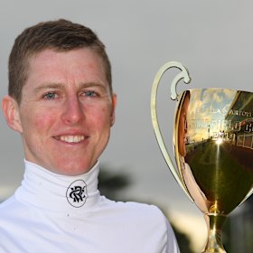Damian Lane poses with the Caulfield Cup after his victory on Mer De Glace.