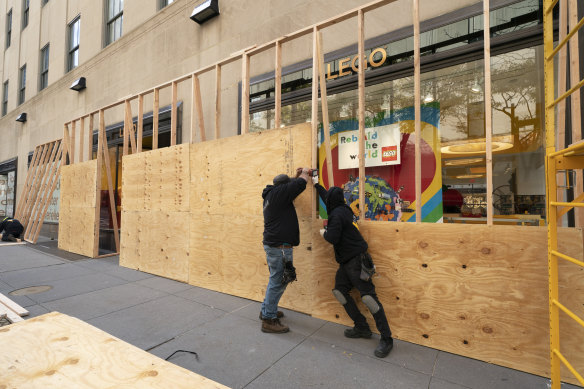 Workers erect a plywood wall to protect a LEGO store in Rockefeller Centre in New York ahead of the contentious presidential election. 