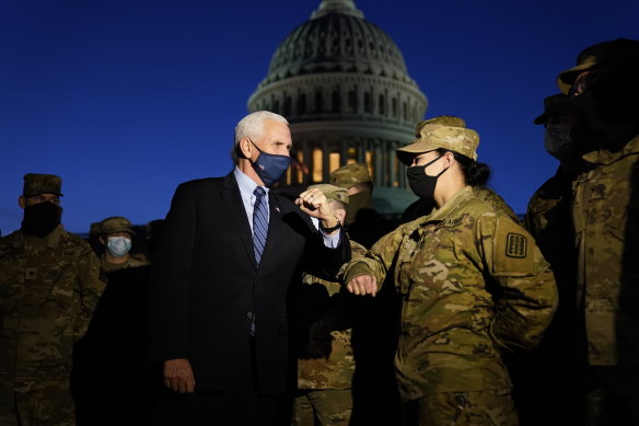 Vice-President Mike Pence elbow bumps with a member of the National Guard as he speaks to troops outside the Capitol on Thursday evening.