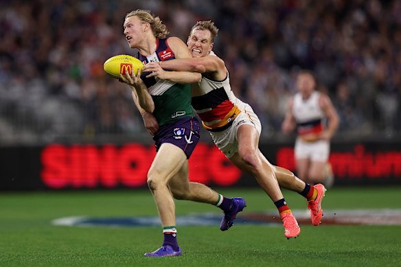 Hayden Young of the Dockers is tackled by Jordan Dawson of the Crows.