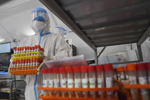 A worker moves samples at a makeshift centre for testing for the coronavirus in Guangzhou.