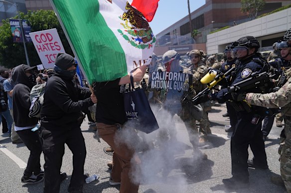 Protesters clash with National Guard troops and police in downtown Los Angeles on Sunday.