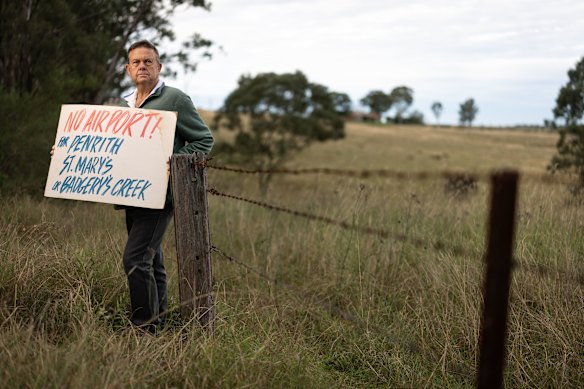 Luddenham resident Wayne Willmington holds an old “no airport” placard.