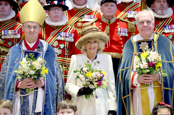 Queen Camilla holds a traditional Nosegay bouquet as she poses with Yeomen of the Guard and and religious representatives during The Royal Maundy Service at Worcester Cathedral on March 28.