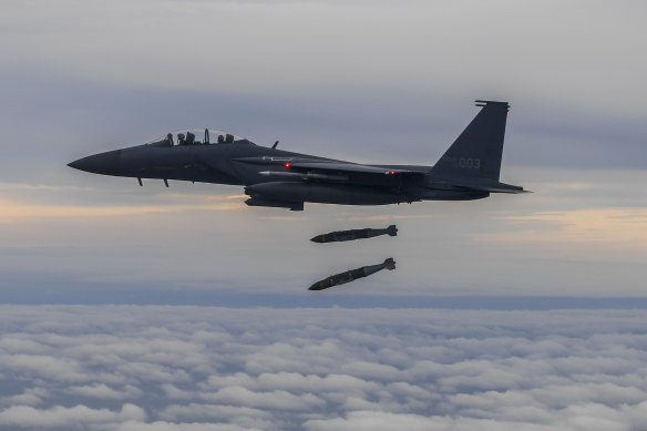 An F15 fighter jet fires two Joint Direct Attack Munitions.