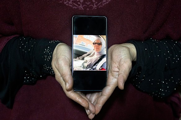 A relative holds a photo of Samaher Esmail, a 46-year-old mother of Palestinian origin and resident of New Orleans detained by Israel over social media posts, at the family home in the West Bank town of Silwad.