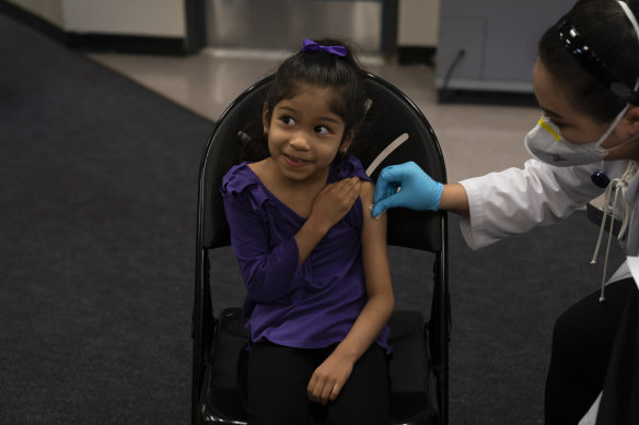Elsa Estrada, 6, smiles at her mother prior to receiving the Pfizer COVID-19 vaccine in Santa Ana, California.