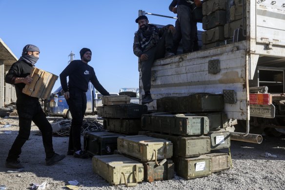 Syrian opposition fighters seize abandoned Syrian army ammunition in in the town of Khan Assubul. 