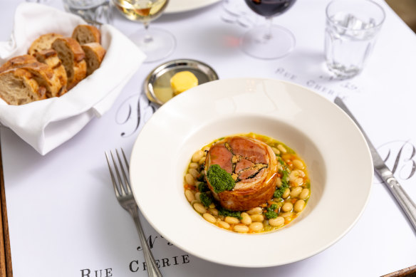 Saddle of White Pyrenees lamb atop cassoulet-style white beans flecked with carrot.