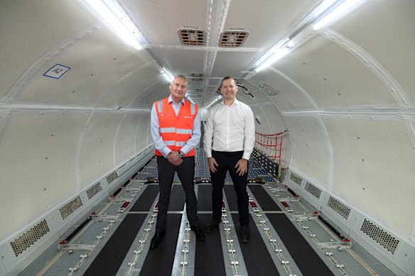 Australia Post’s Mark Davies, left, and Qantas Freight executive manager Igor Kwiatkowski inside the A321 which has had its entire interior stripped out for cargo operations.