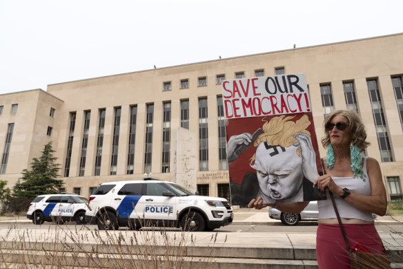 Voter Nicky Sundt holds a banner outside the Federal District Court this week.