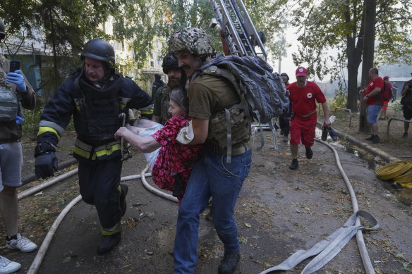 Rescuers carry a resident injured by the Russia’s guided air bomb strike in Kharkiv on Friday.