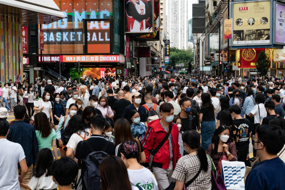 Residents cross an intersection at a shopping district in Hong Kong, China. The world’s population is slated to reach 8 billion on November 15.