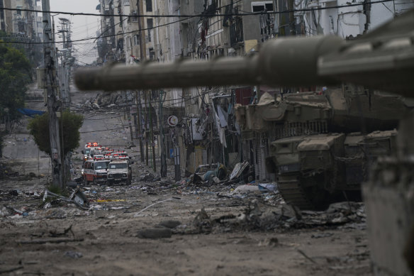 Ambulances are seen on a road near an Israeli army tank during an IDF ground operation in the Gaza Strip.