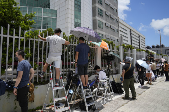 Reporters waiting outside Apple Daily on Thursday morning as police combed through files inside. 