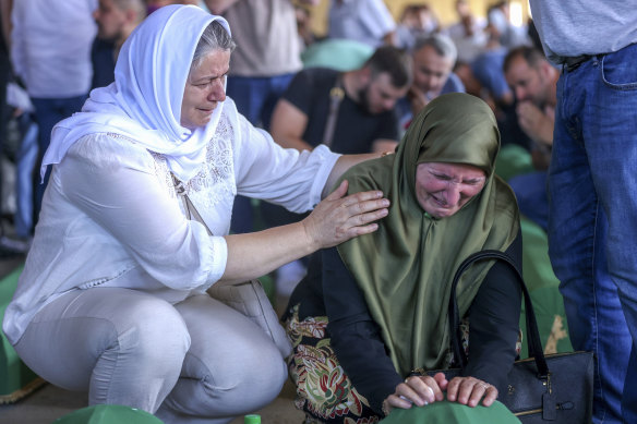 Women mourn next to the coffin of their relative, a victim of the 1995 Srebrenica genocide in Potocari. The remains of the 30 recently identified victims are to be buried on the 28th anniversary of the massacre.