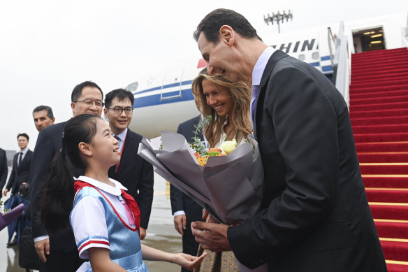 Syrian President Bashar al-Assad, right, and first lady Asma al-Assad receive a bouquet of flowers from a young girl as they arrive in Hangzhou, China, on September 21.