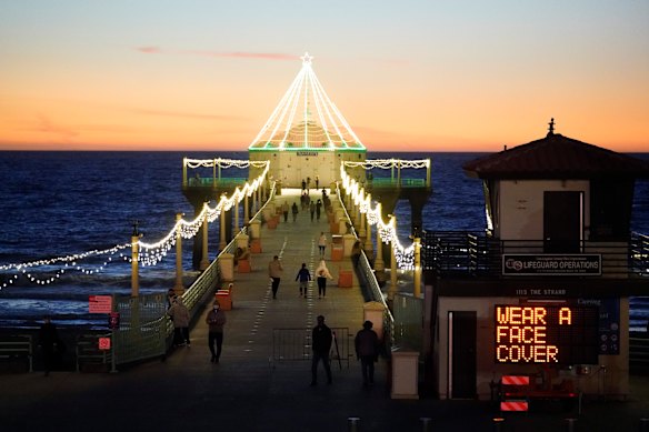 A sign at Manhattan Beach urges people to wear masks as the California death toll soars. 