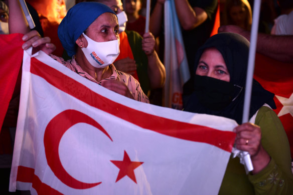 Supporters of the newly elected Turkish Cypriot leader hold the breakaway region's flag while celebrating the election results in the Turkish occupied area in the north part of the divided capital Nicosia.