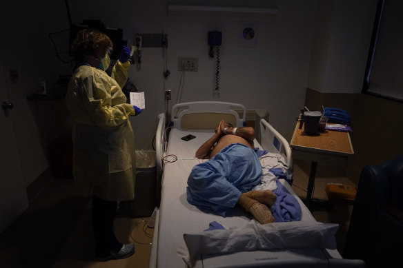  Senior chaplain Nancy Many, left, prays with Rafael Lopez in a COVID-19 unit at Providence Holy Cross Medical Centre, Los Angeles. 