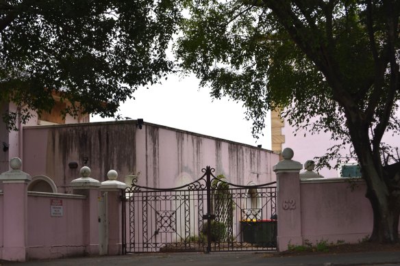 The front gates of the pink mansion on Wynnum Road, beneath the towering fig trees. 
