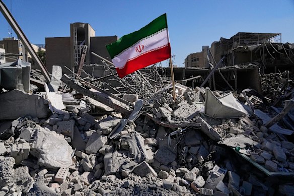 An Iranian flag is placed among the ruins of a police station struck during the US-Israeli attacks. 