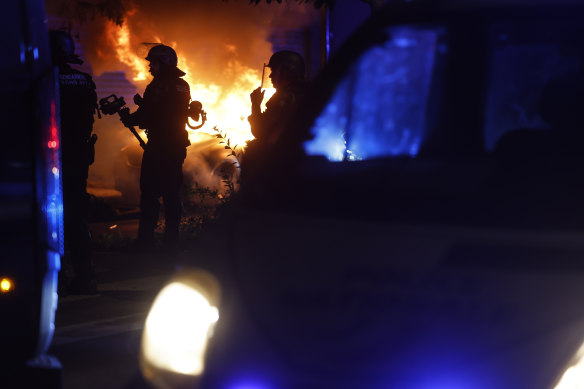 Riot police stand near a burning car in the La Meinau neighbourhood of Strasbourg, in eastern France.