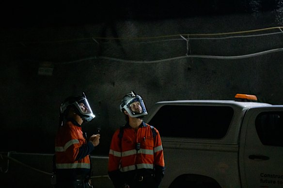Workers wearing respirator masks check out the roof of an M6 tunnel.