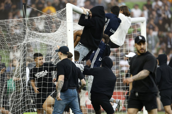 Fans storm the pitch during the eighth round of the A-League Men's League Melbourne derby. 