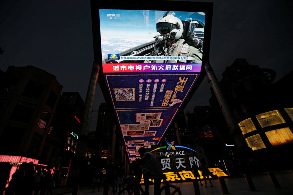 A screen in a Beijing shopping area broadcasts footage of the military drills in the Taiwan Strait.