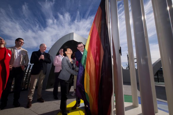 Victorian Premier Daniel Andrews and Victorian Pride Centre chair Hang Vo raise a rainbow flag.