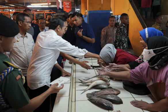 Indonesian President Joko Widodo greets people at Pal Merah traditional market, in Jakarta.