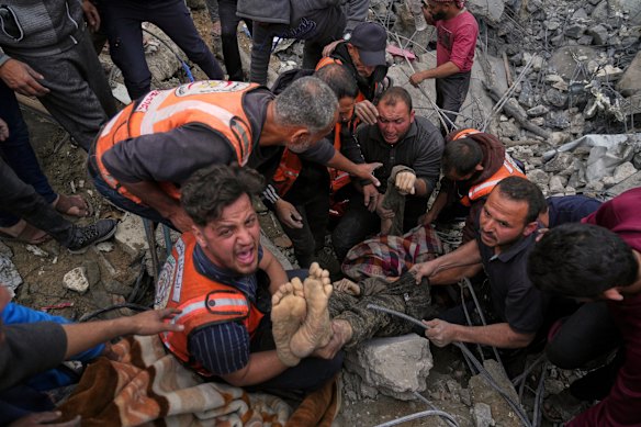 A dead man is removed from the rubble of the Manoun family’s house after it was targeted by an Israeli army strike in Jabalia al-Balad, Gaza City on Sunday.